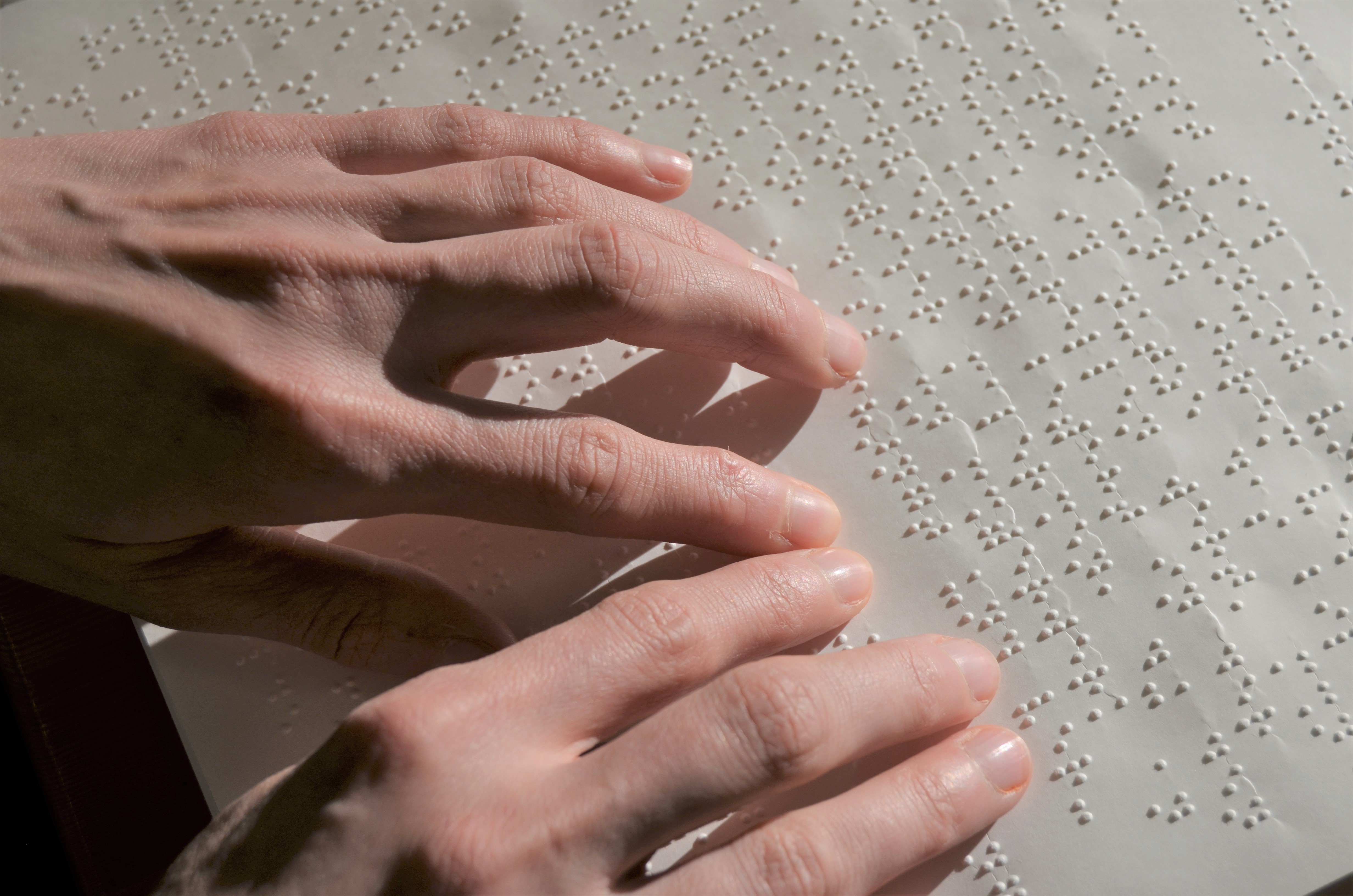 zwei Hände lesen Brailleschrift