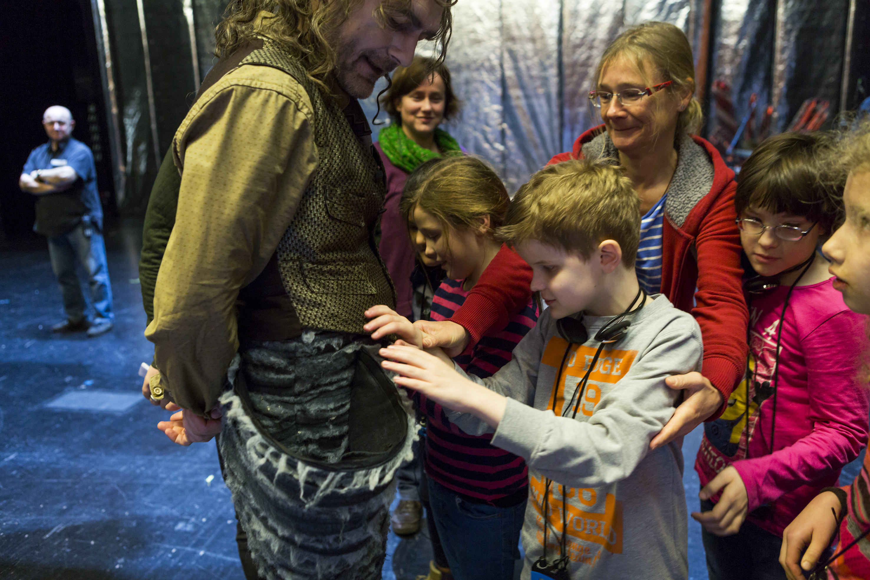 Kinder ertasten das Kostüm vom Urfin (vor der Vorstellung „Der schlaue Urfin und seine Holzsoldaten)