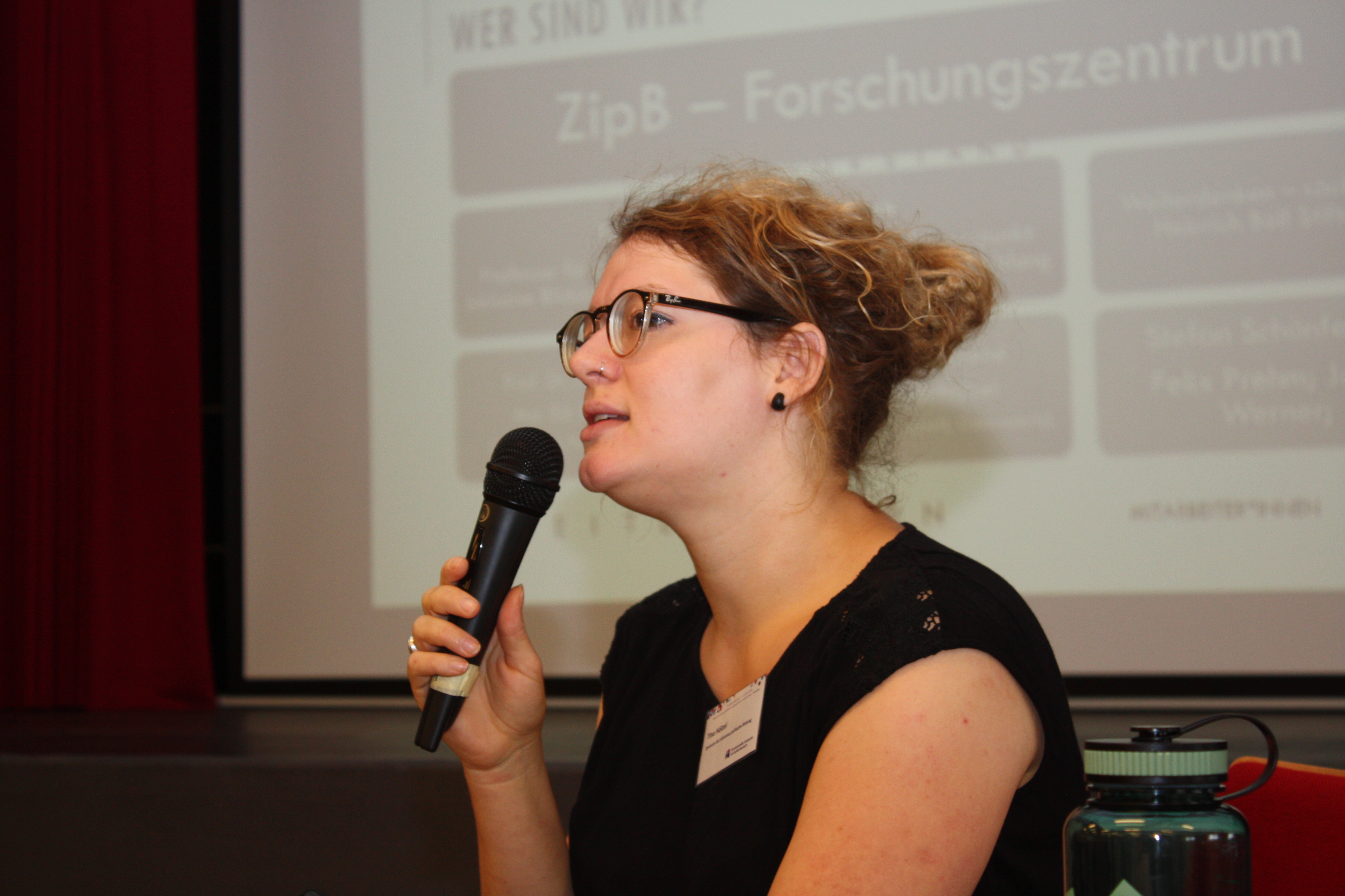 Referentin spricht ins Mikrofon