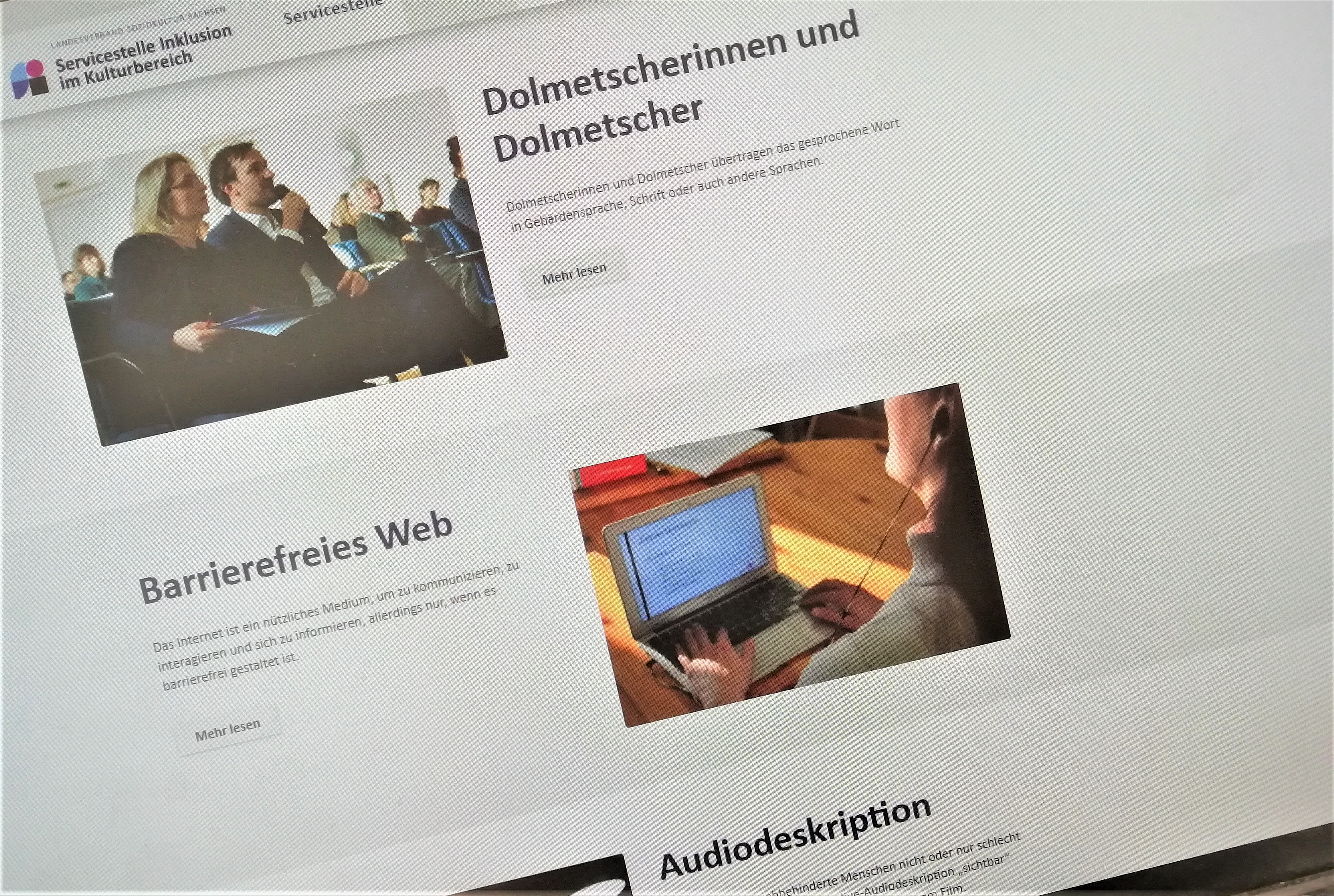 Das Foto zeigt einen Screenshot des Infoportals der Servicestelle. Zu sehen sind drei Informationsabschnitte untereinander, jeweils mit Text und Foto daneben. Der erste Abschnitt: Dolmetscherinnen und Dolmetscher, der zweite: Barrierefreies Web, der dritte: Audiodeskription.