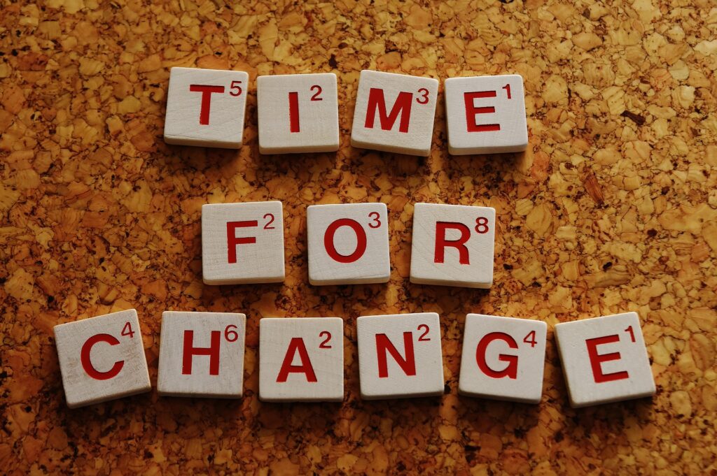 Das Foto zeigt auf Holzwürfel gedruckte Buchstaben, die den Schriftzug "Time for change" ergeben.